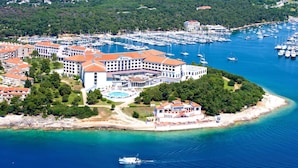 An aerial view of a coastal hotel with multiple buildings, a marina, and a beach. - Park Plaza Histria Pula (Pula)