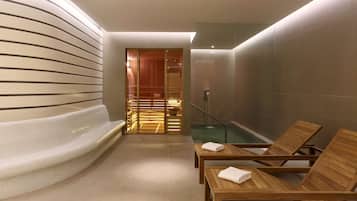 Relax in a serene spa area with a heated seating area, hot tub, and lounge chairs.