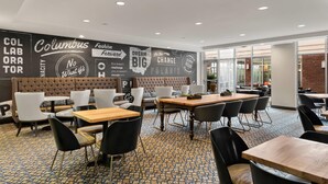 A modern cafe with a patterned floor, leather seating, and motivational wall art. - Cambria Hotel Columbus - Polaris (Columbus)