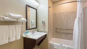 A modern bathroom with a sink, mirror, towel rack, and a walk-in shower.