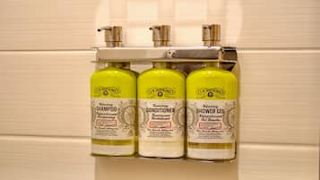 Un estante de baño con tres productos J.R. Watkins: champú, acondicionador y gel de ducha.