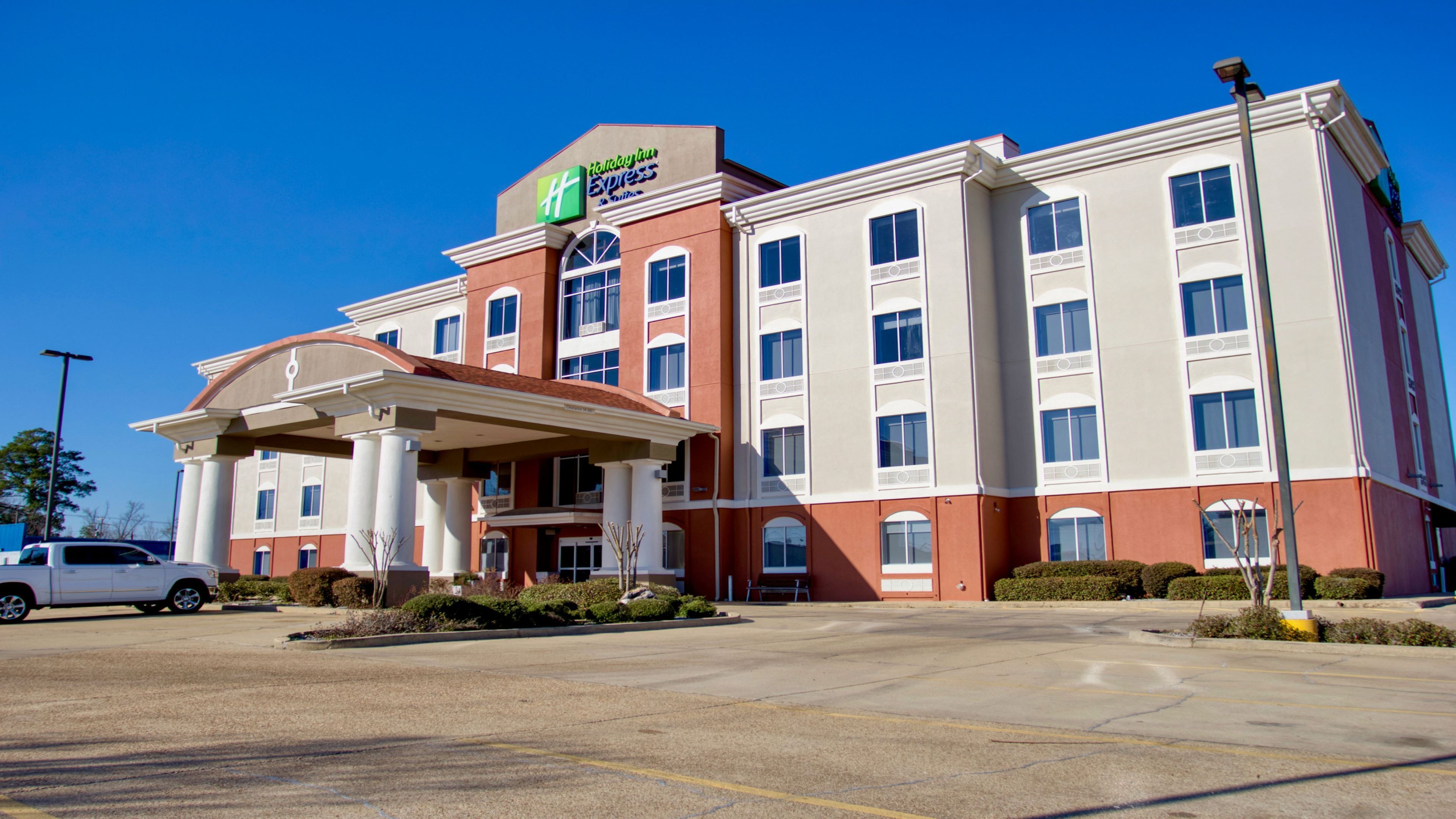 Um hotel Holiday Inn Express com entrada central, vários andares e estacionamento.