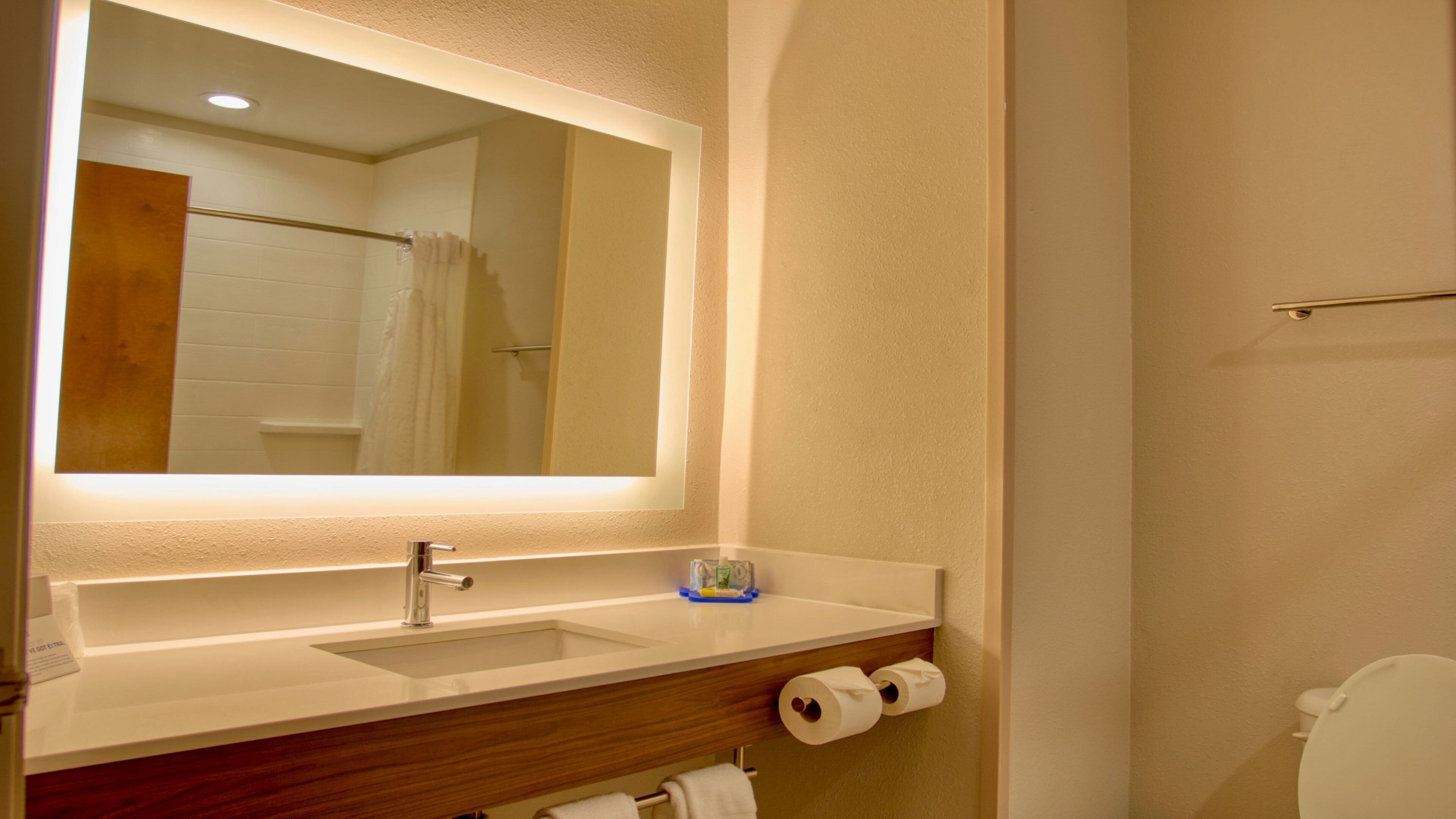 Ein Badezimmer mit Spiegel, Waschbecken und Toilette.