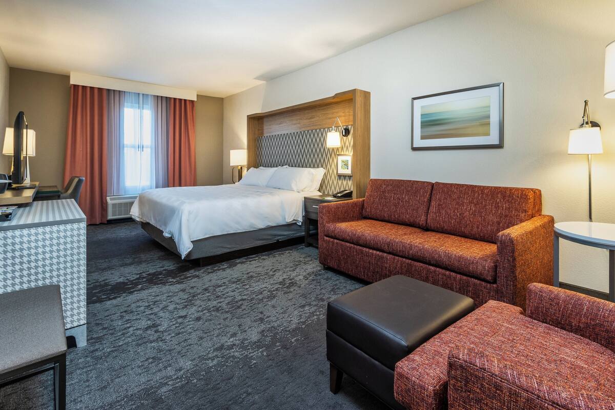 Een hotelkamer met een bed, een bank, een bureau en een stoel.