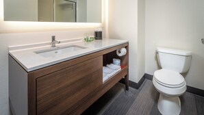 Une salle de bain moderne avec un lavabo blanc, un meuble-lavabo en bois et des toilettes.