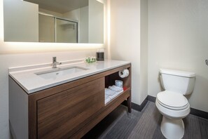 Une salle de bain moderne avec un lavabo blanc, un meuble-lavabo en bois et des toilettes.