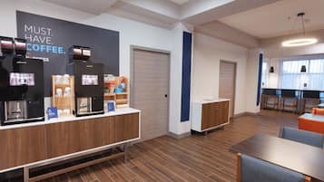 A modern coffee station with espresso machines, a counter, and seating area.