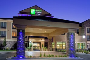 A Holiday Inn Express & Suites building with a modern design, featuring a prominent entrance and illuminated pillars. - Holiday Inn Express & Suites Logan by IHG (Logan)