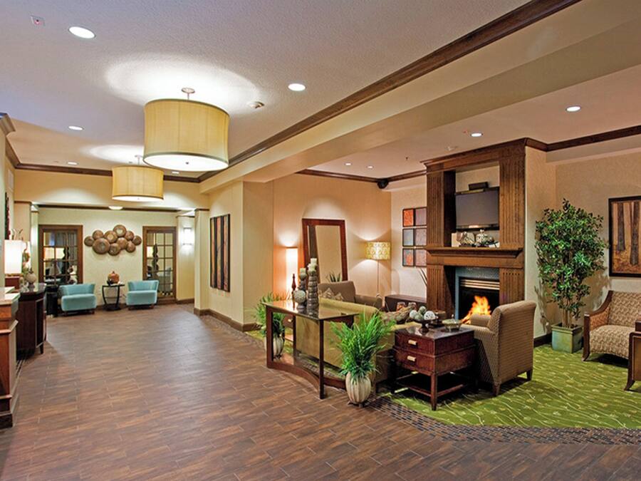 A spacious lobby with a fireplace, seating area, and a dining area.