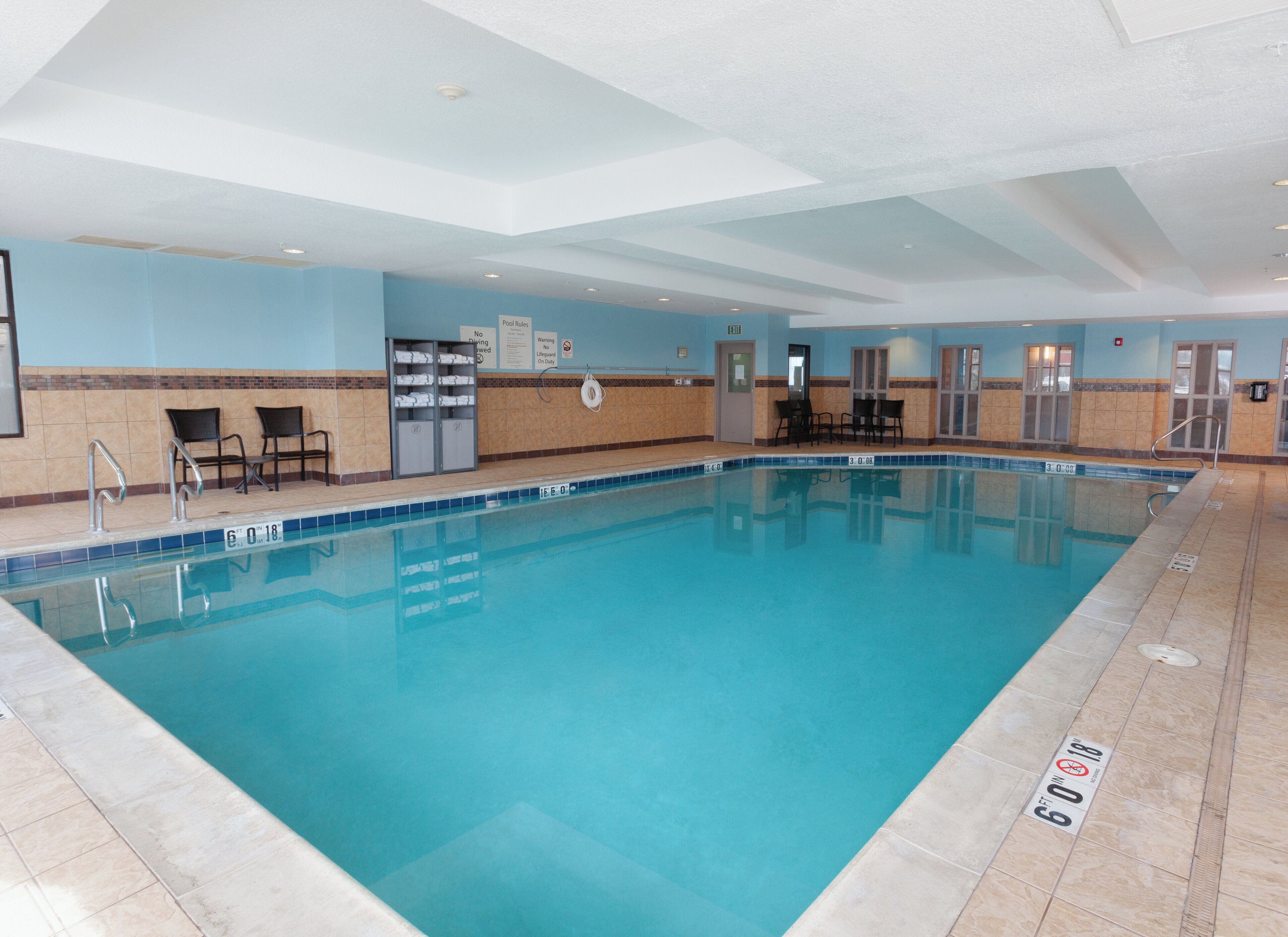 Una piscina techada, sillones reclinables de piscina