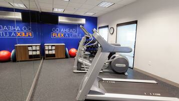 A gym with treadmills, exercise balls, and a wall with motivational text.