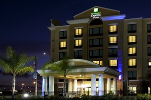 Un hotel Holiday Inn Express & Suites con un cartello ben visibile, diversi balconi e un ingresso luminoso.