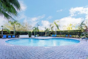 Una piscina al aire libre, sillones reclinables de piscina