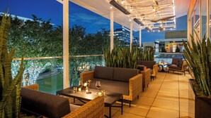 An outdoor patio area with seating, a table, and a view of the cityscape. - The Moran CITYCENTRE (Houston)