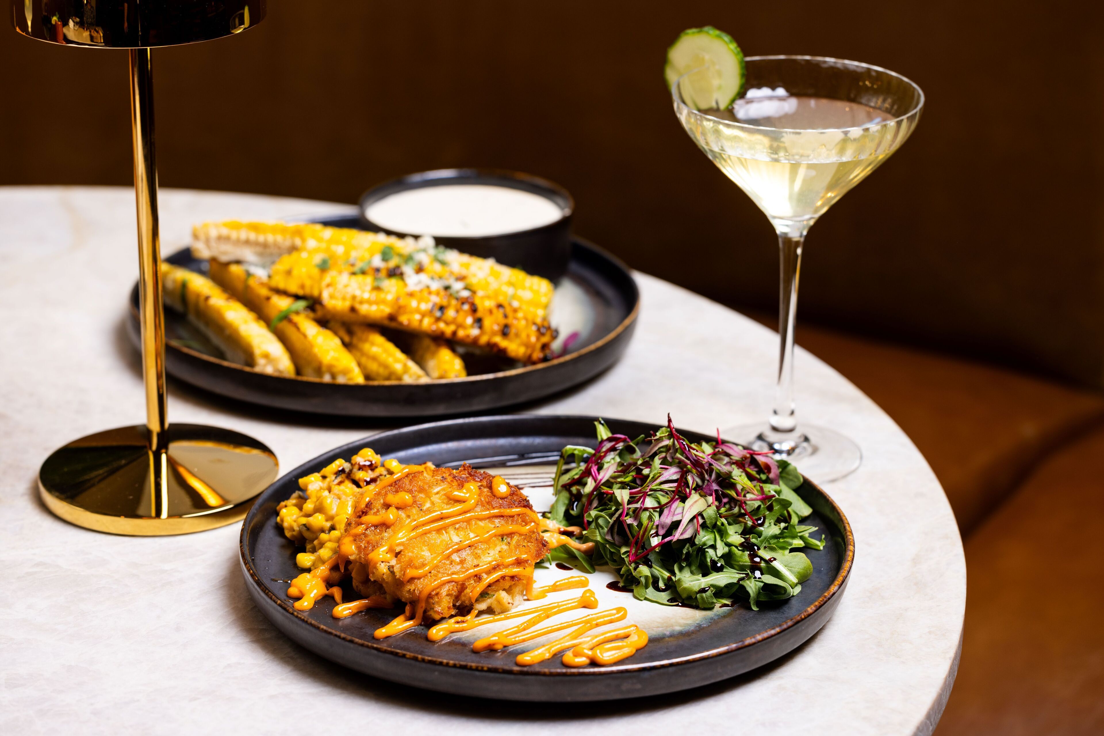 A table with plates of food and a martini glass.