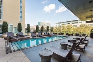 Una piscina al aire libre, sillones reclinables de piscina