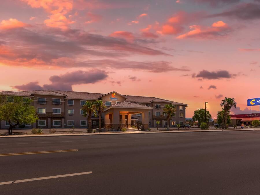 A hotel with a prominent entrance, multiple floors, and a parking lot.