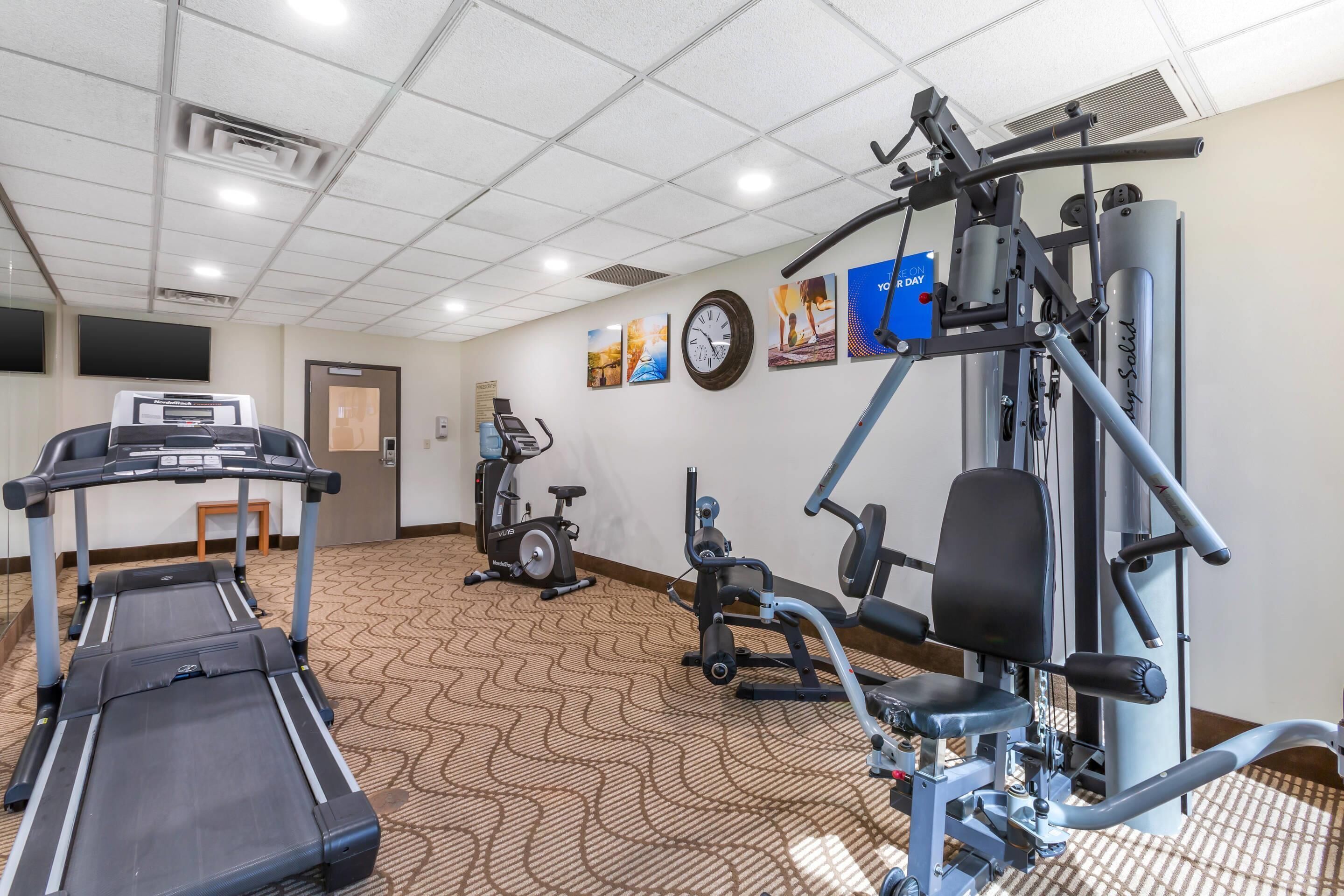 A gym with treadmills, an elliptical, and weight machines.