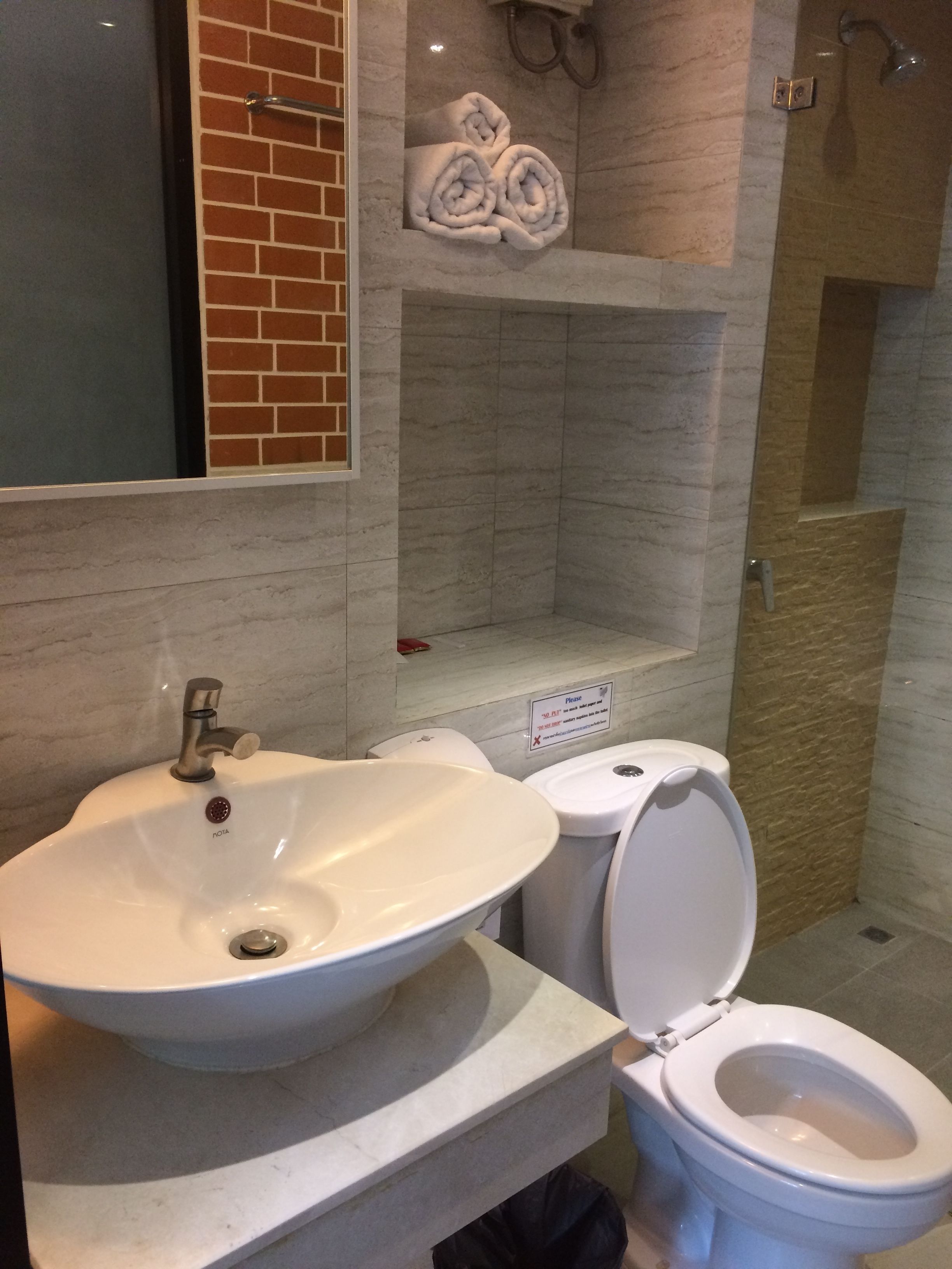Une salle de bain équipée d’un lavabo, de toilettes et d’un porte-serviettes avec des serviettes.