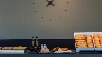 A buffet setup with various food items, including meats, cheeses, and breads, and a clock on the wall.