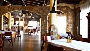 Un restaurante con arcos de piedra, mesas y sillas de madera.