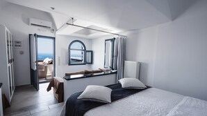 Habitació d'hotel moderna amb llit, finestra amb vistes, escriptori petit i bany.
