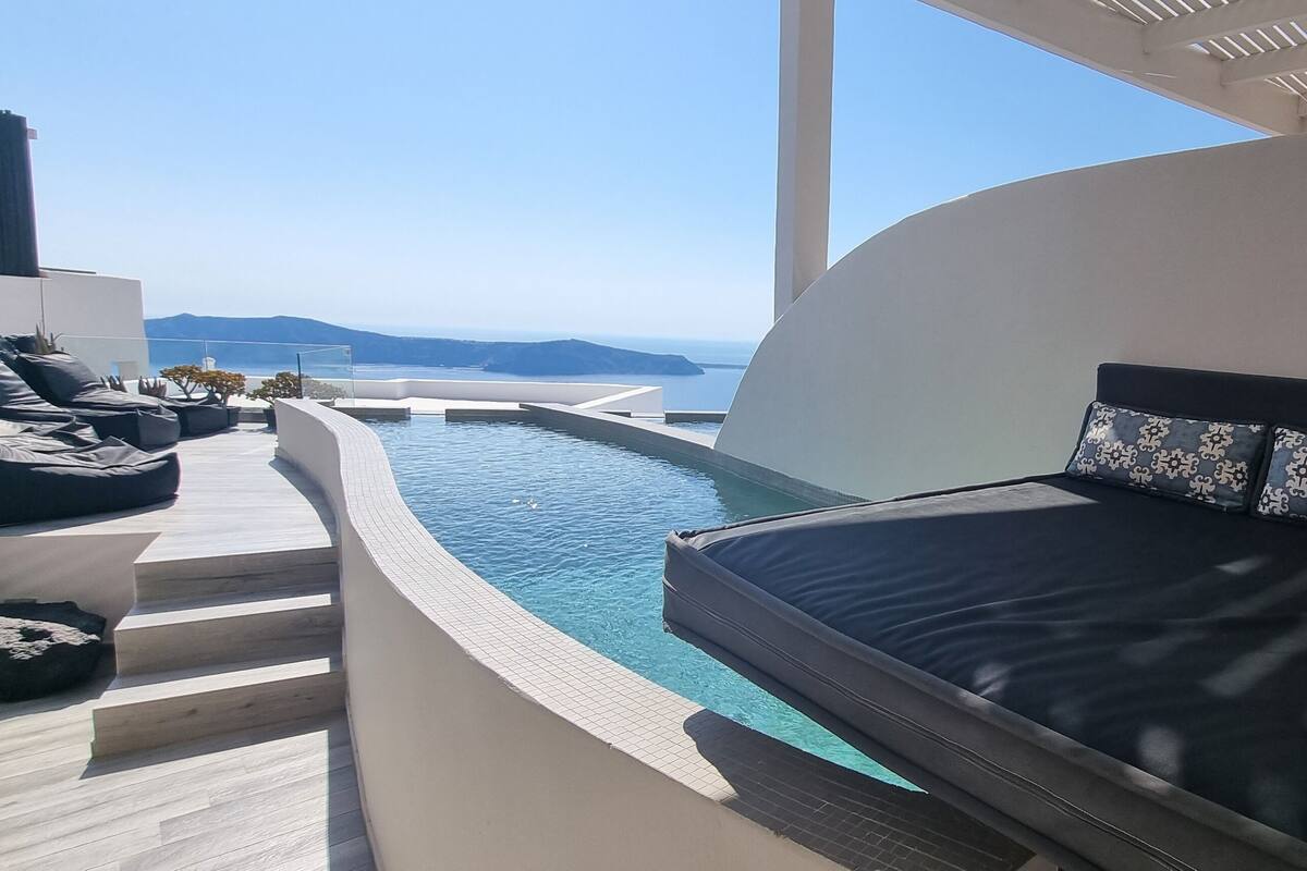 A modern bedroom with a large bed, a built-in pool, and a view of the sea.