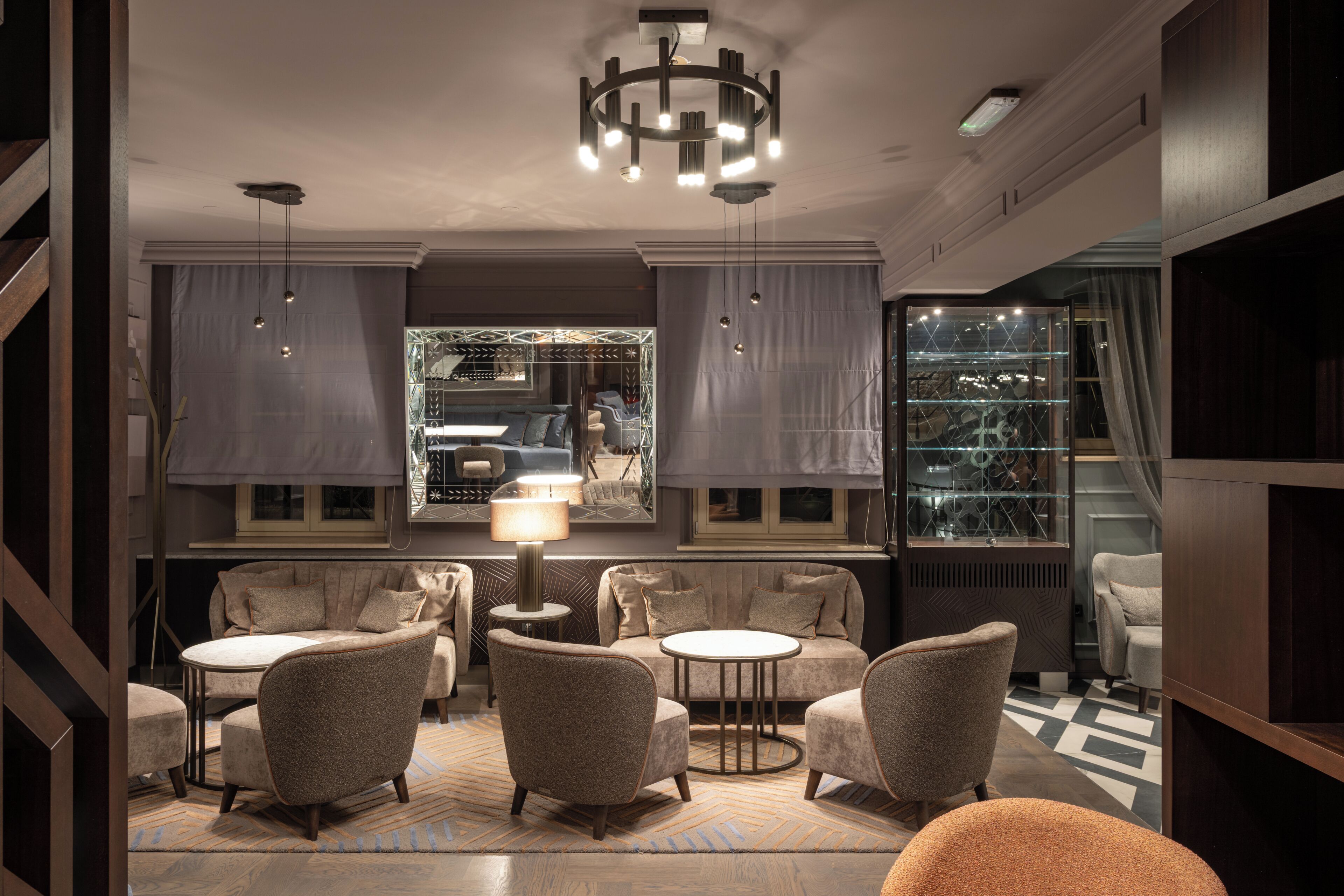 A modern interior with a sofa set, round tables, and pendant lighting.