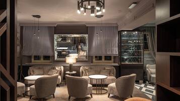 A modern interior with a sofa set, round tables, and pendant lighting.