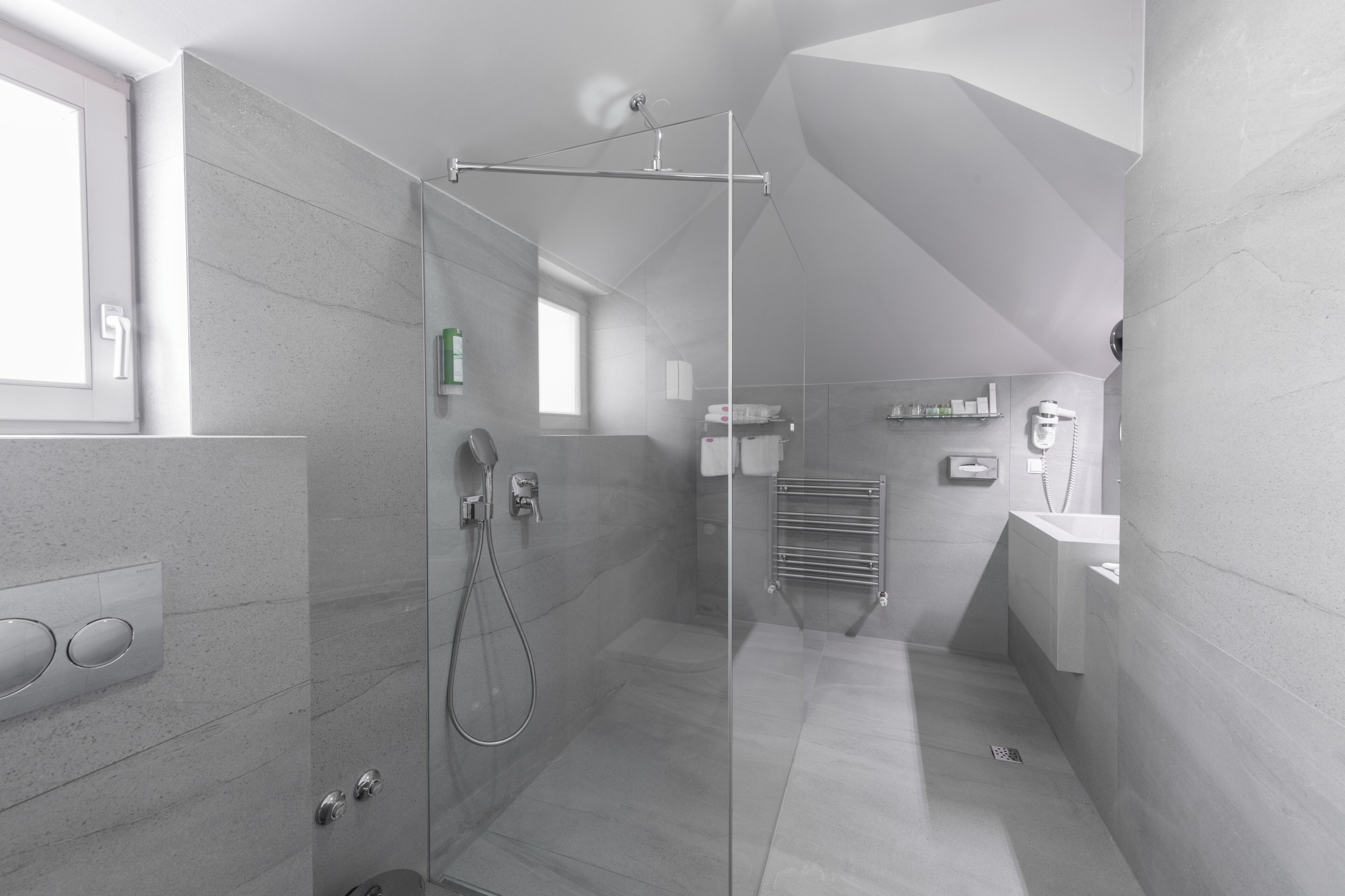 A modern bathroom with a glass-enclosed shower, a built-in sink, and a towel rack.