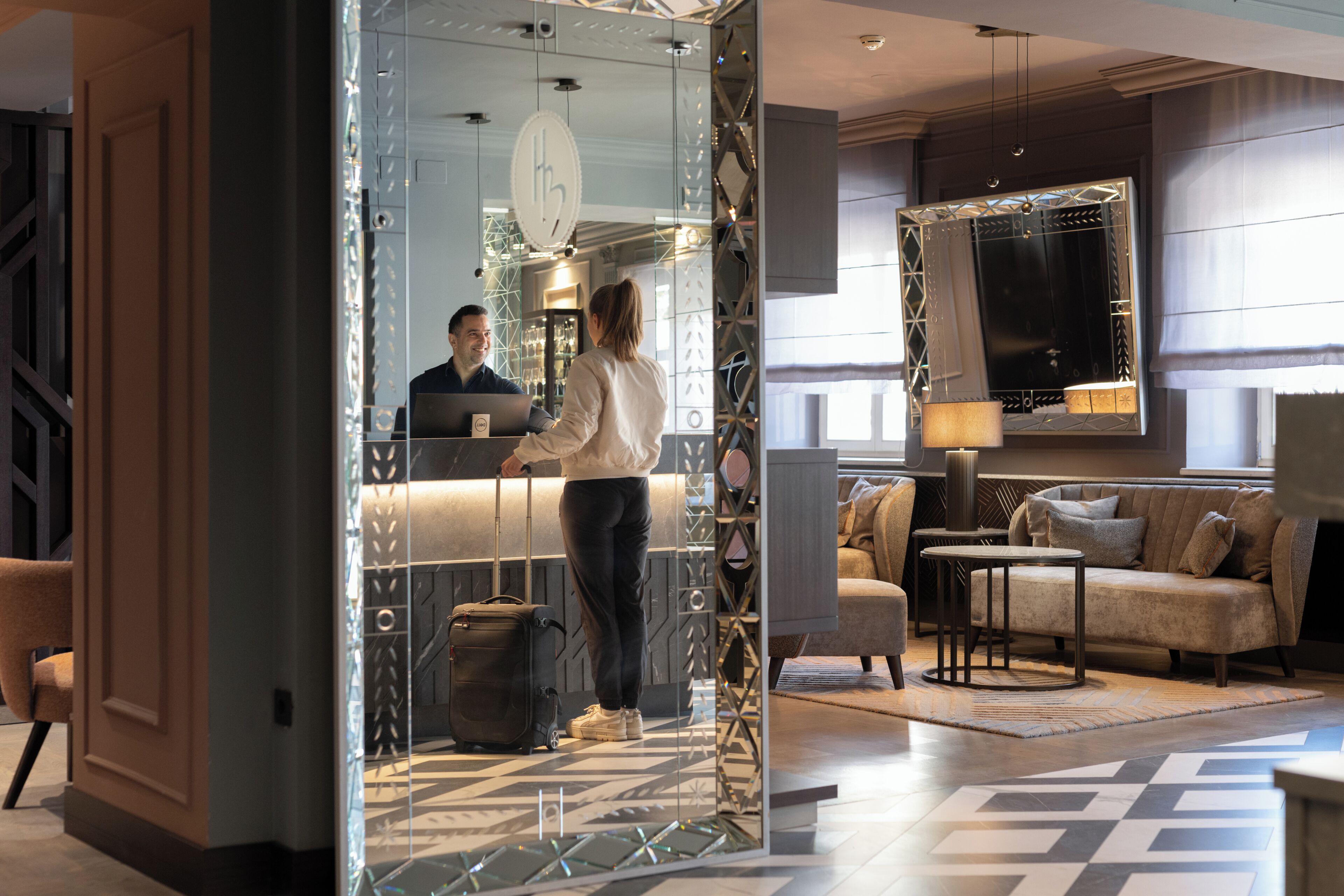 Eine moderne Hotelhalle mit einer Rezeption, einer Sitzecke und einem Fernseher.