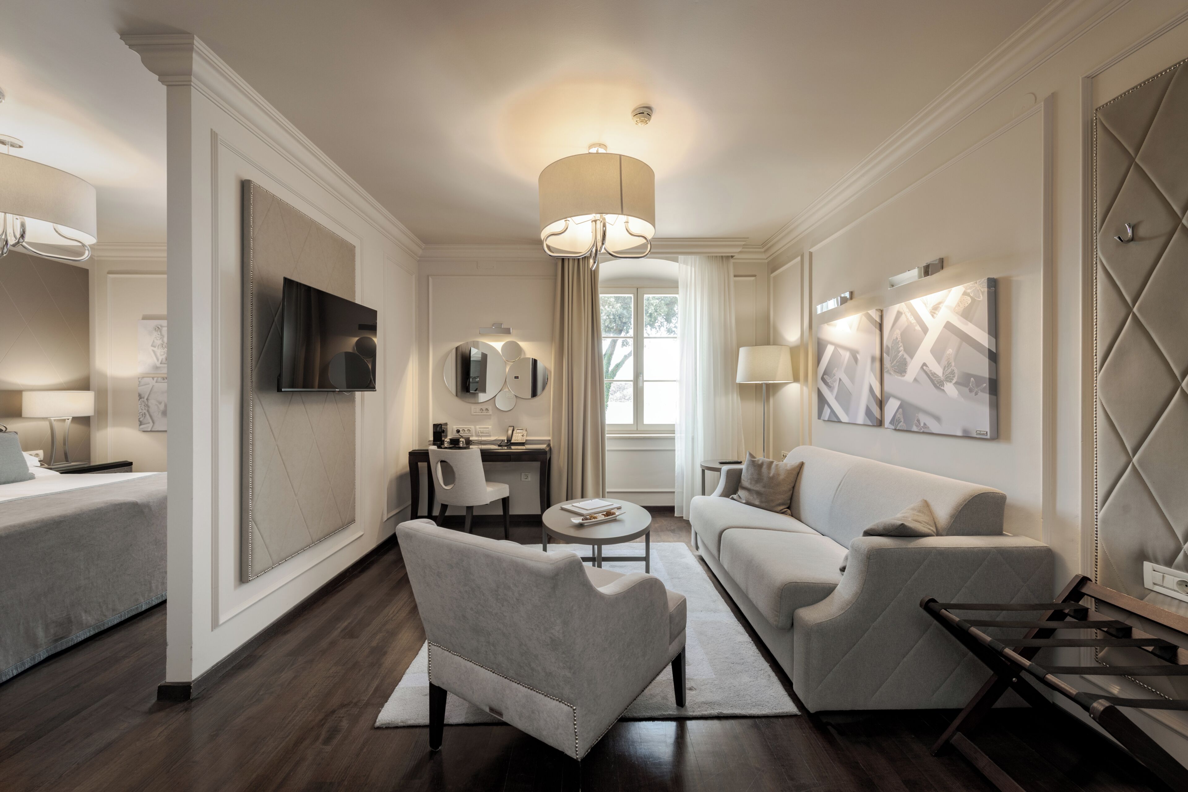 Una sala de estar moderna con sofá, sillón, televisor y un comedor con mesa y sillas.