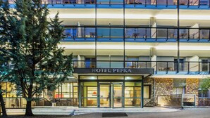 A hotel with a modern design, featuring a glass facade, multiple balconies, and a sign reading "HOTEL PEFKA". - Pefka Hotel (Pylaia-Chortiatis)