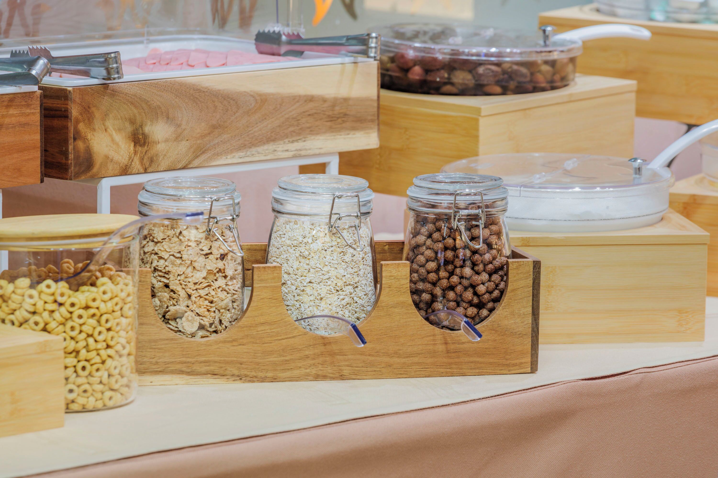A buffet with various food items in glass jars and wooden containers.