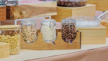 A buffet with various food items in glass jars and wooden containers.