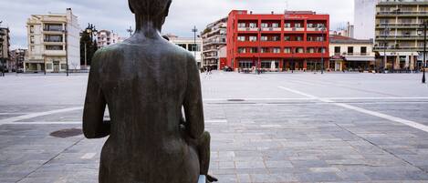 A statue in a public square with buildings in the background.