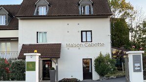 A two-story building with a sign reading "Maison Cabotte."