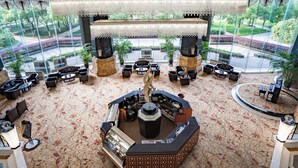 A lobby with a central bar area, multiple seating arrangements, and large windows offering a view of the outdoor area. - Holiday Inn Changzhou Wujin by IHG (Changzhou)