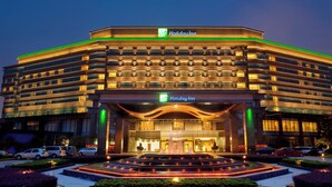 A Holiday Inn hotel with a modern design, multiple floors, and a well-lit entrance. - Holiday Inn Changzhou Wujin by IHG (Changzhou)