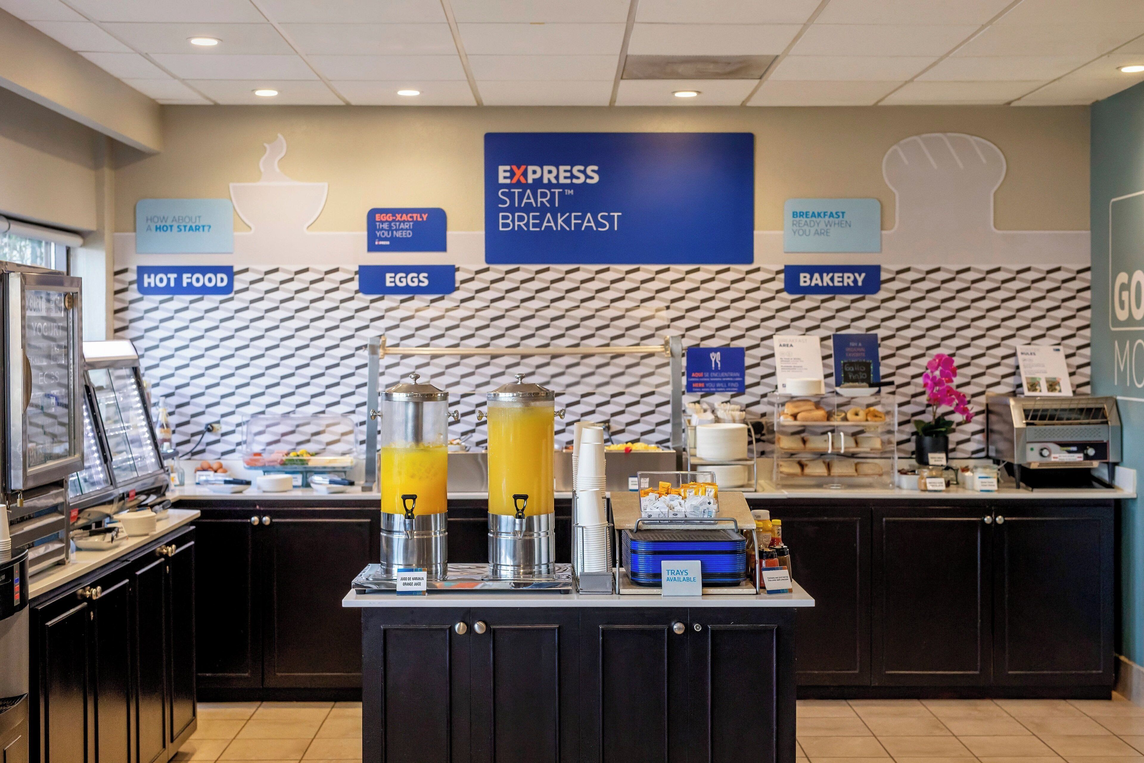 A breakfast bar with hot food, eggs, and bakery options.