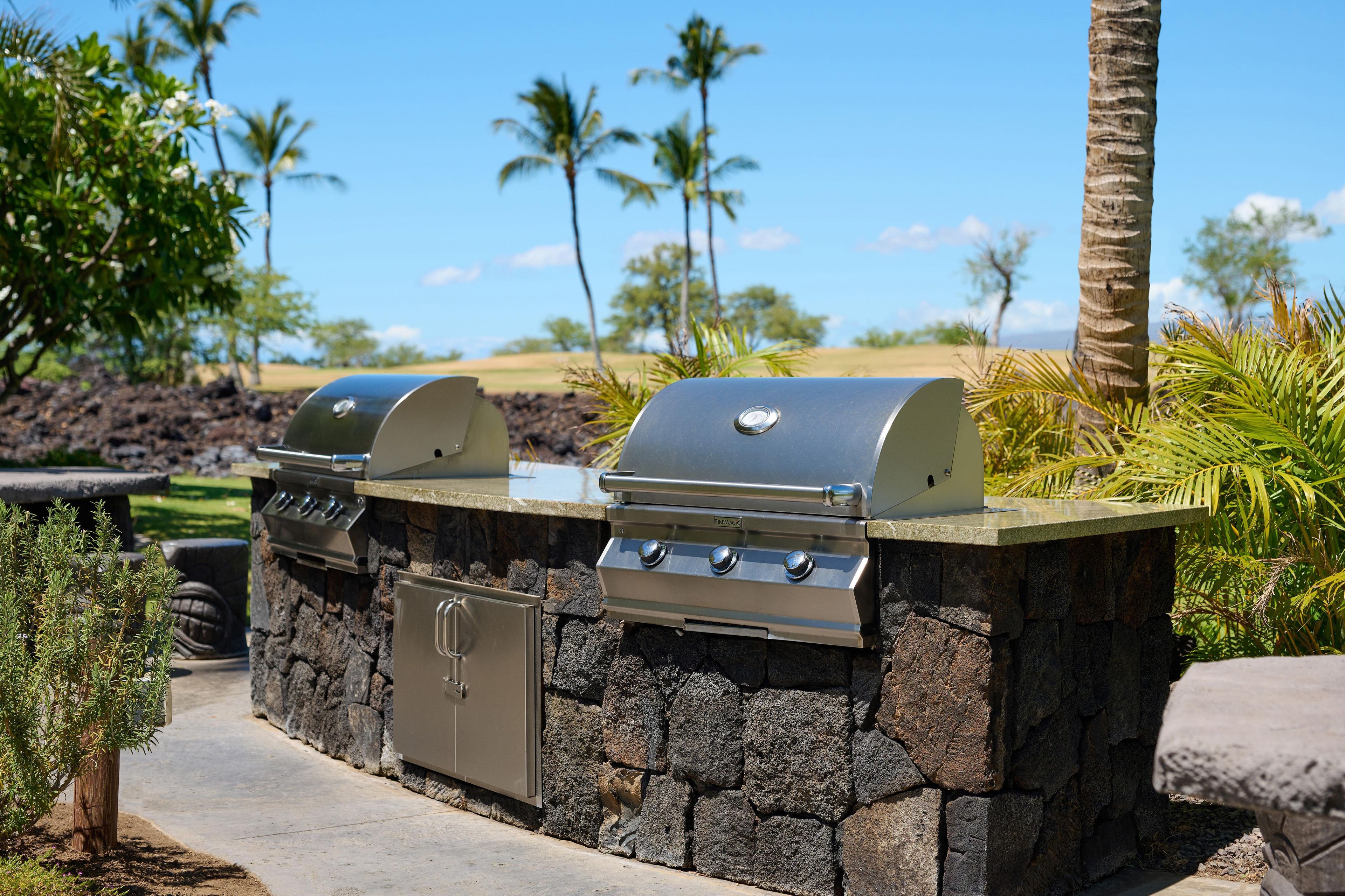 A stone-built outdoor grill area with a built-in cabinet and a flat-top grill.