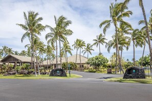 A resort with palm trees, a covered walkway, and a Clubhouse sign. - Hilton Grand Vacations Club Kings’ Land Waikoloa (Waikoloa)
