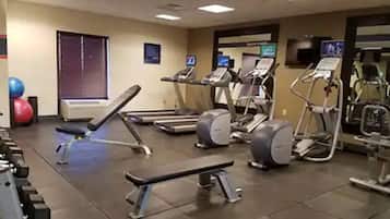 A gym with treadmills, elliptical machines, and free weights.