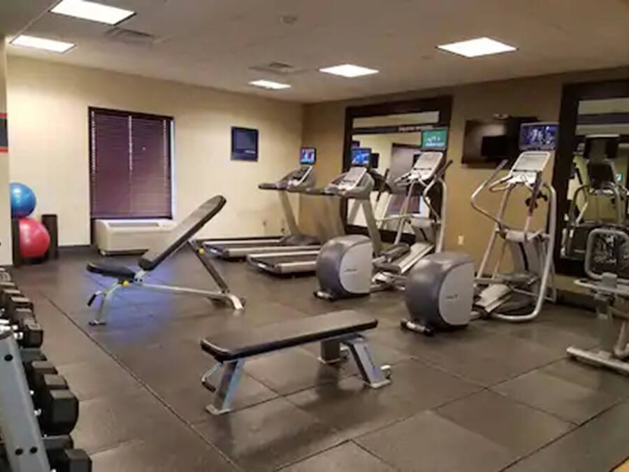 Un gimnasio con cintas de correr, elípticas y pesas sueltas.