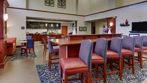 Eine großzügige Lobby mit Barbereich, Sitzgelegenheiten und einem Fernseher.