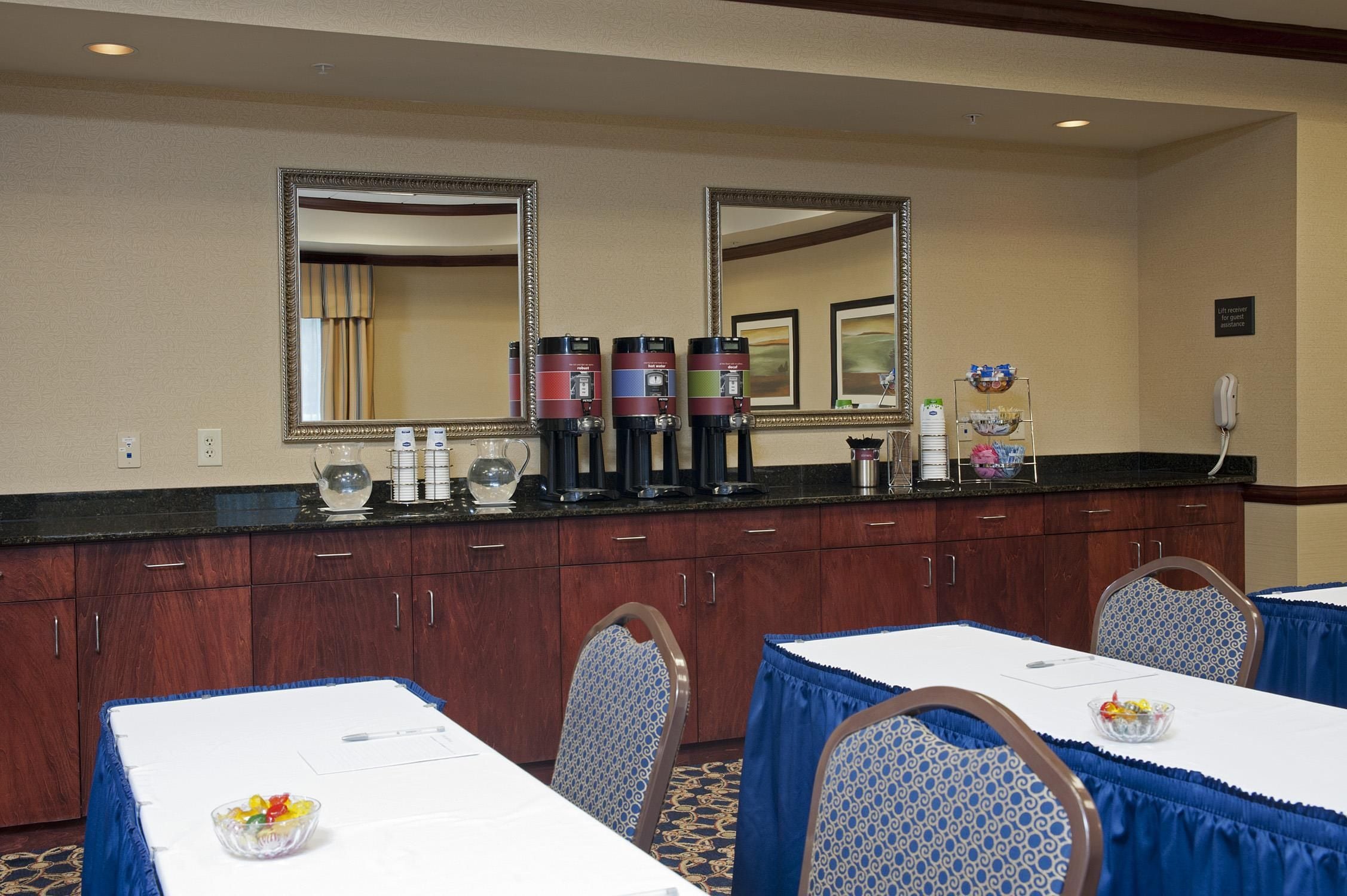 A hotel dining area with a counter, coffee machines, and a lift receiver sign.