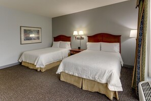 A hotel room with two beds, a nightstand, a lamp, and a painting on the wall. - Hampton Inn & Suites Indianapolis-Airport (Indianapolis)