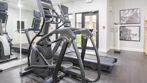 A gym with treadmills, exercise bikes, and a mirrored wall. - Staybridge Suites Lafayette by IHG (Lafayette)