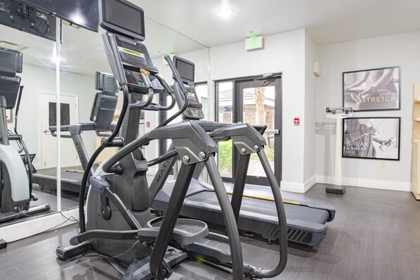 A gym with treadmills, exercise bikes, and a mirrored wall. - Staybridge Suites Lafayette by IHG (Lafayette)