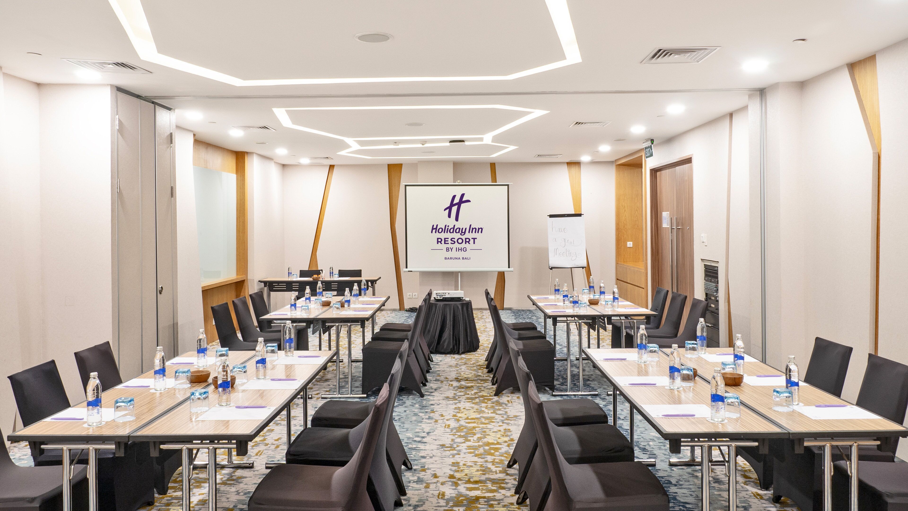 A conference room with multiple tables, chairs, and a whiteboard.